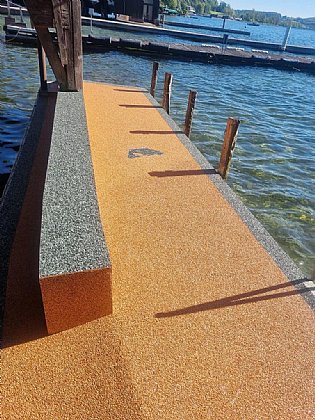 Ein Steg am See mit Steinteppich